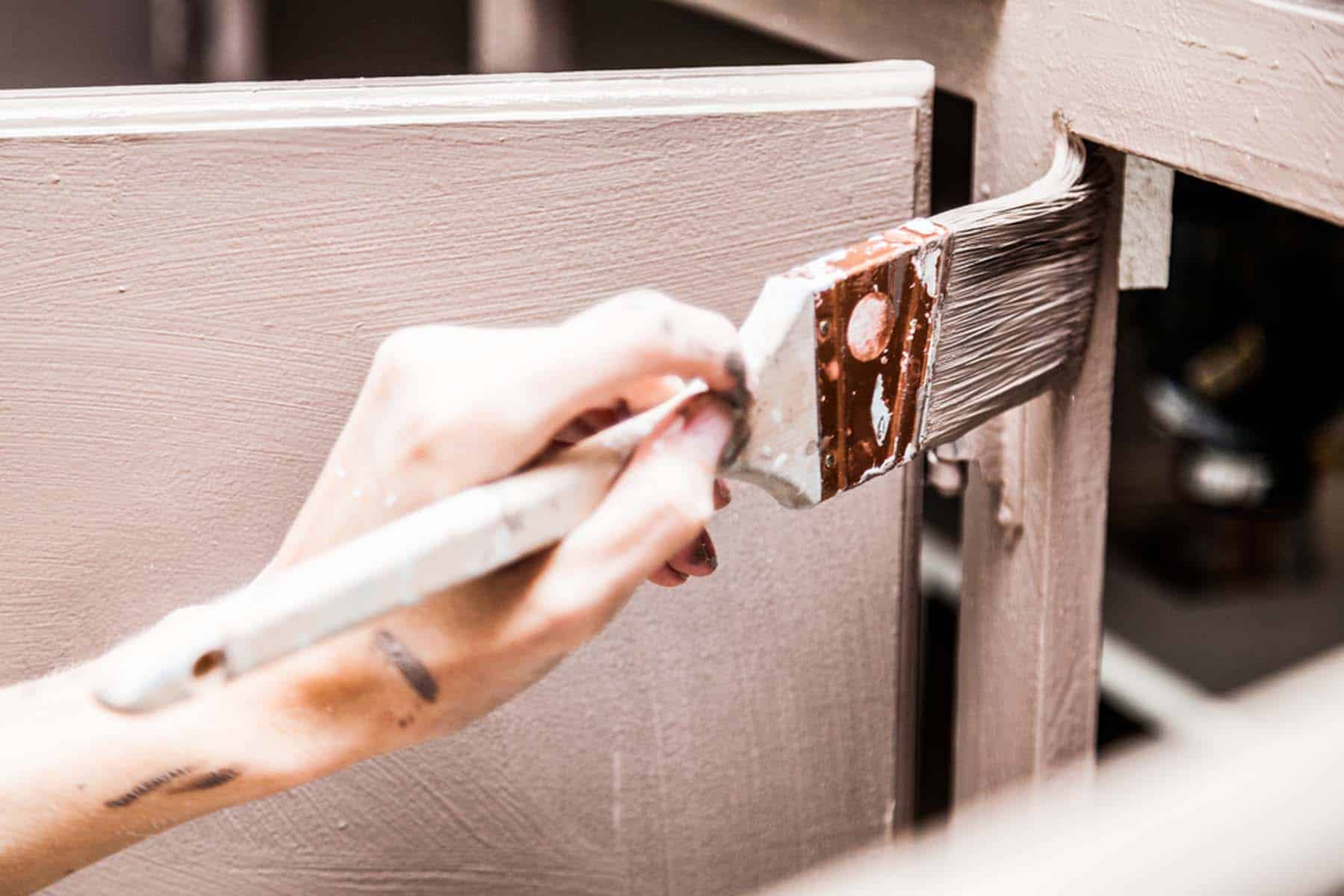 A brush and a scraper working along a painted edge