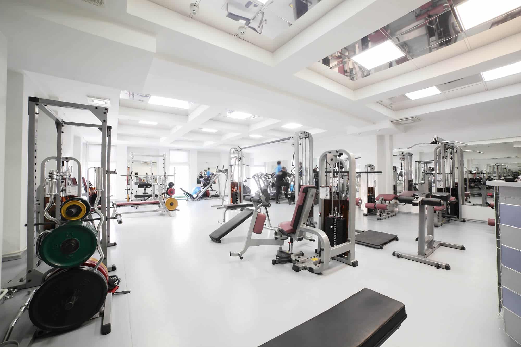A newly painted gym floor with rows of exercise machines