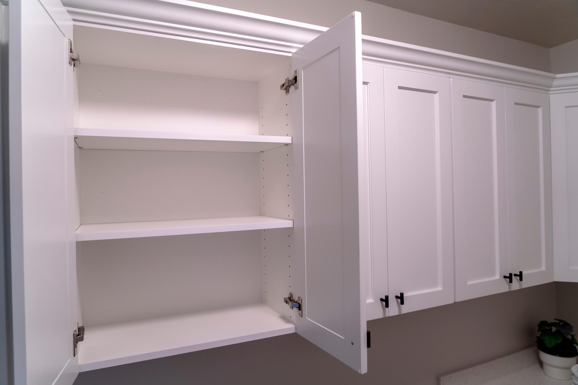 Fitted white cabinets and shelving in a painted finish