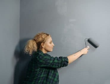 Painter rolling fresh paint on a commercial interior wall