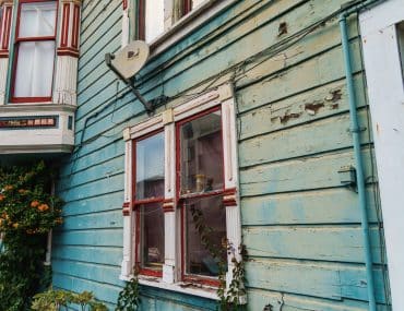 Aged, peeling paint on a wooden home exterior due for repainting