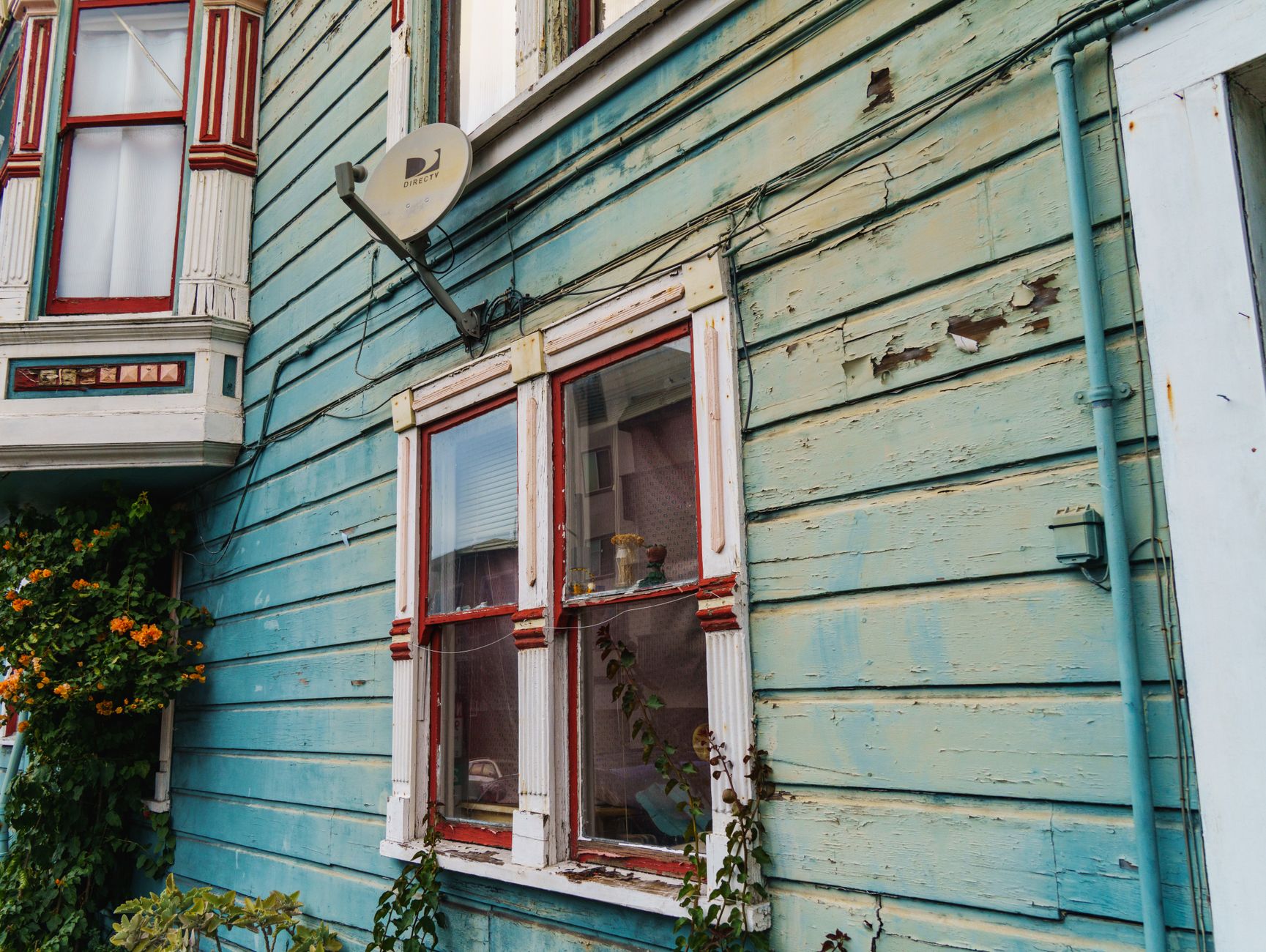A house exterior being repainted section by section