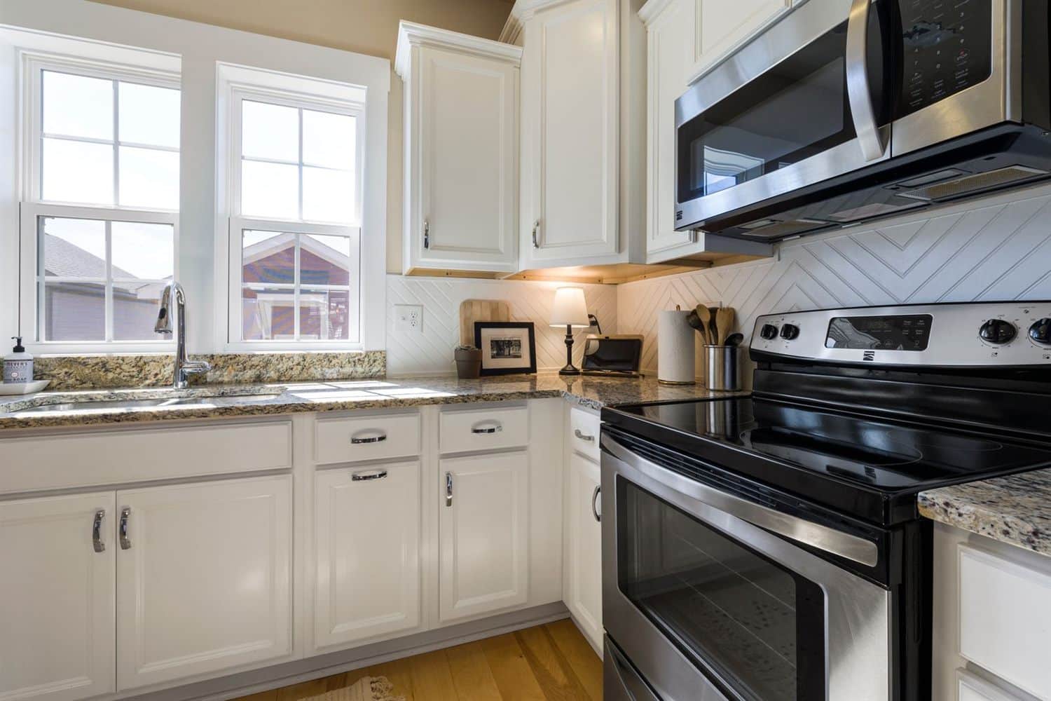 A kitchen with white painted cabinet doors and a range