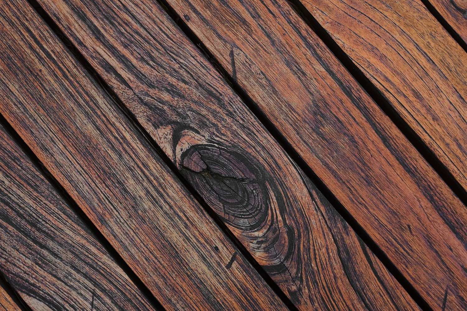 Weathered deck boards in a dark brown coating