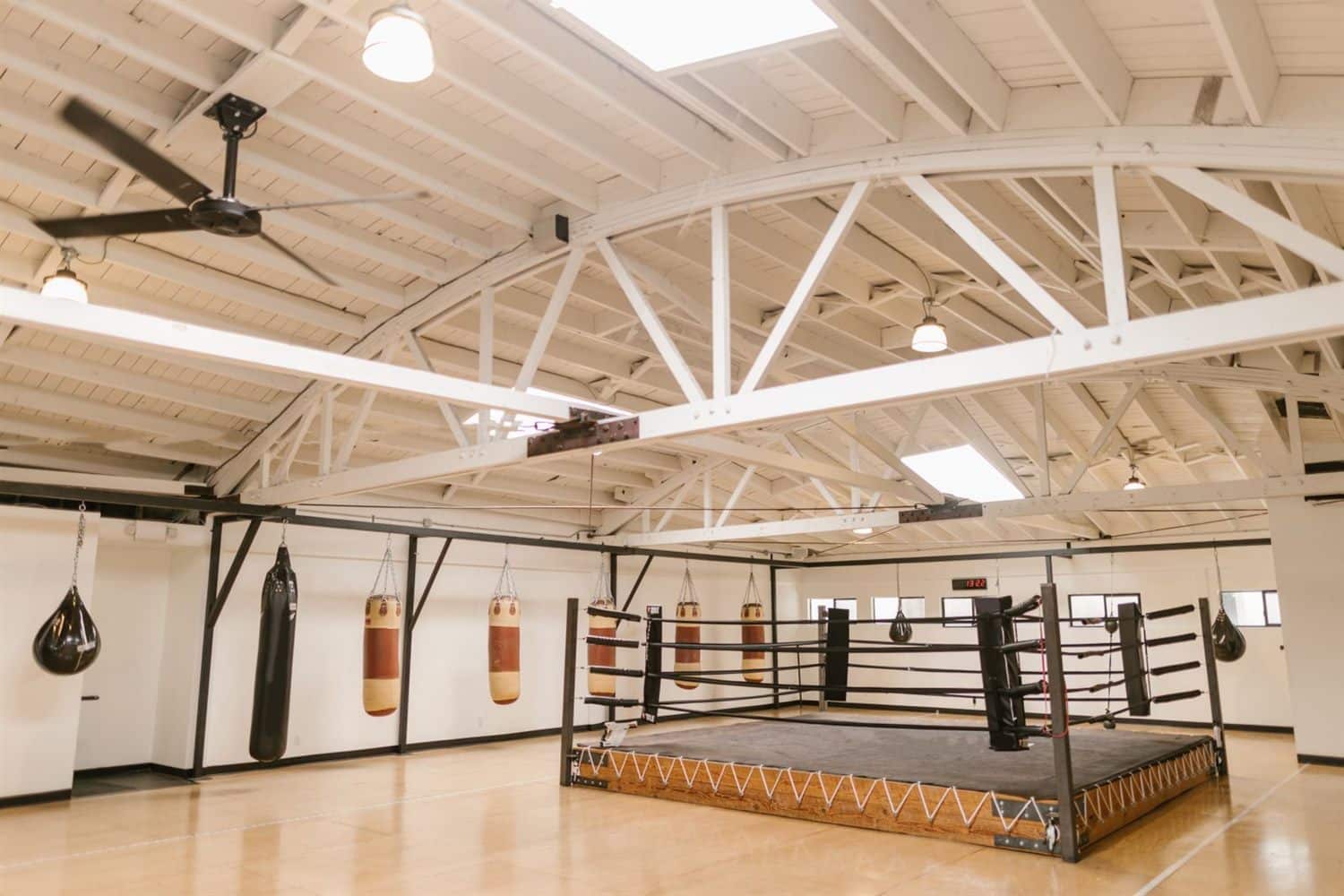 A gym with an open roof structure and equipment along the walls