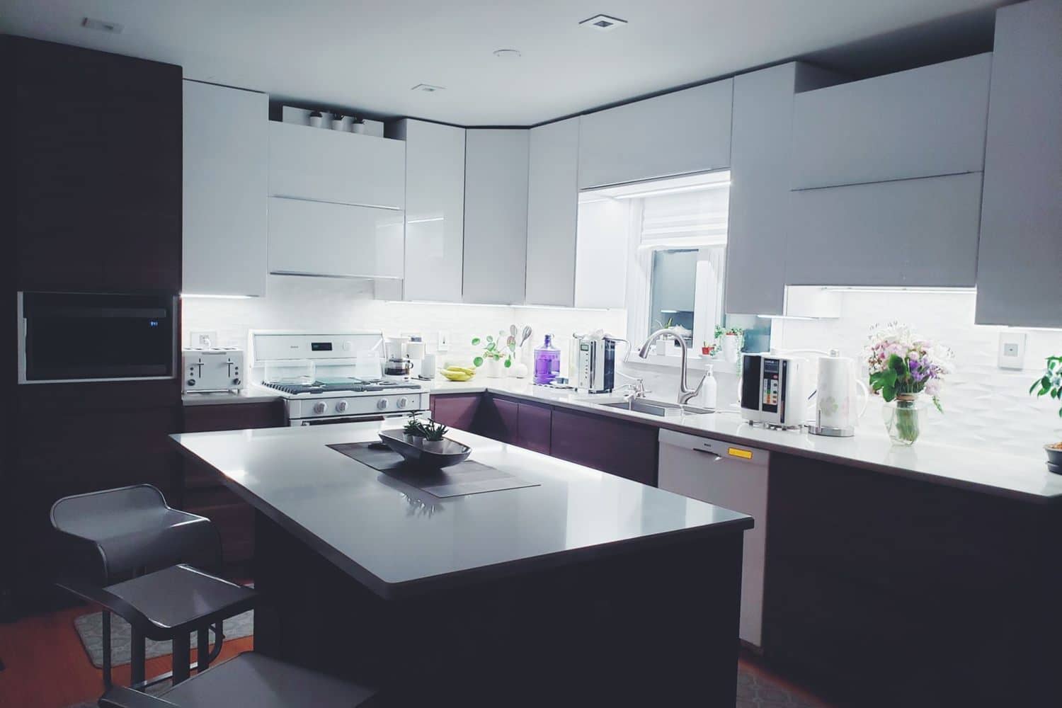 A finished kitchen with an island and dark cabinet fronts
