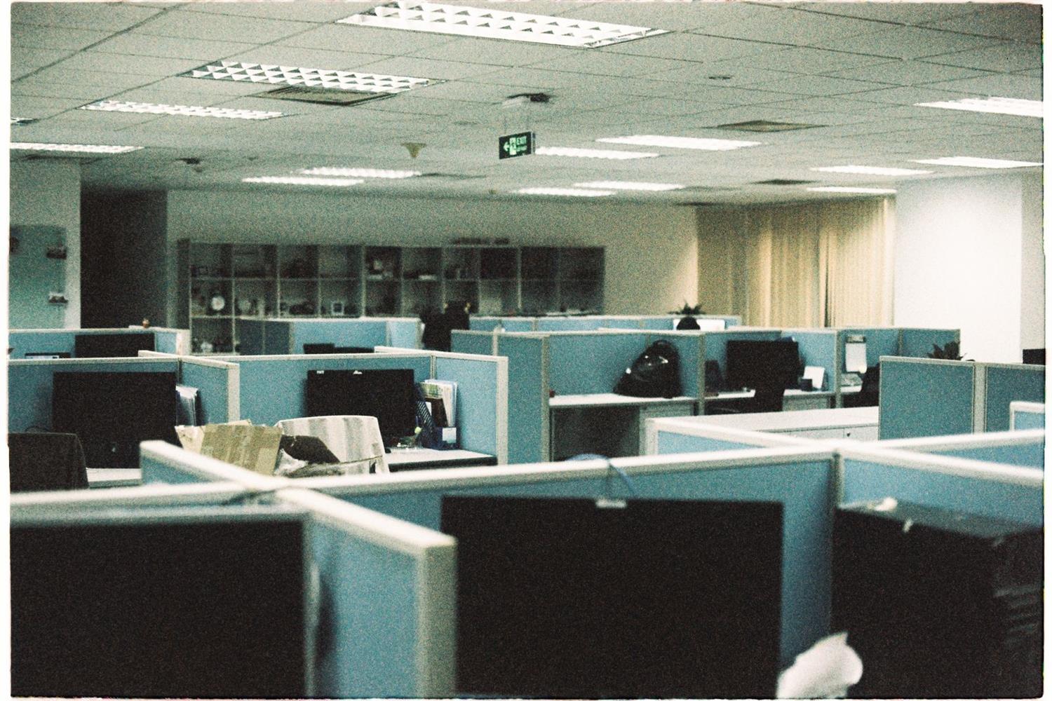 An open plan office floor with desk partitions