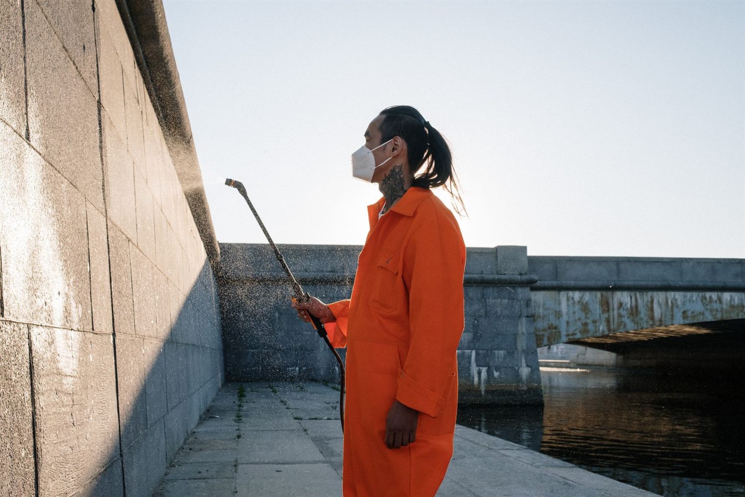 A worker washing the face of a building wall