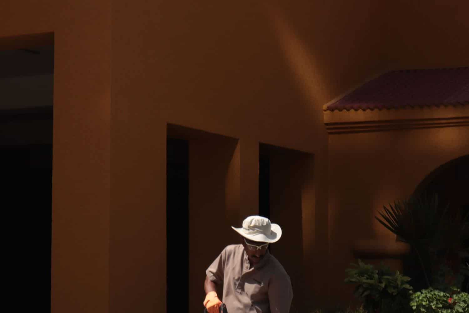 A worker cleaning a paved walkway with a pressure washer