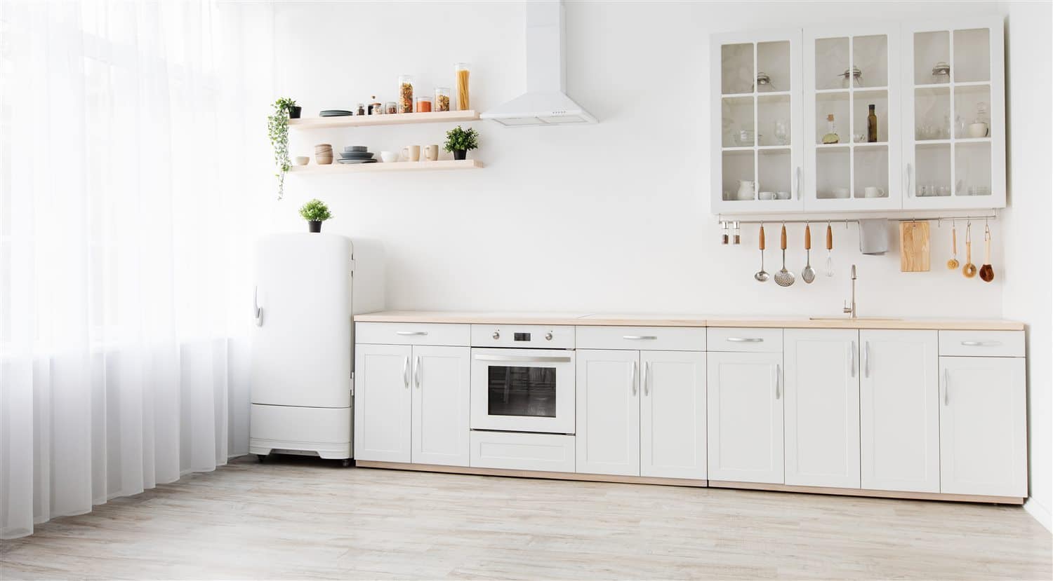 A bright kitchen with white painted cabinets and open shelving