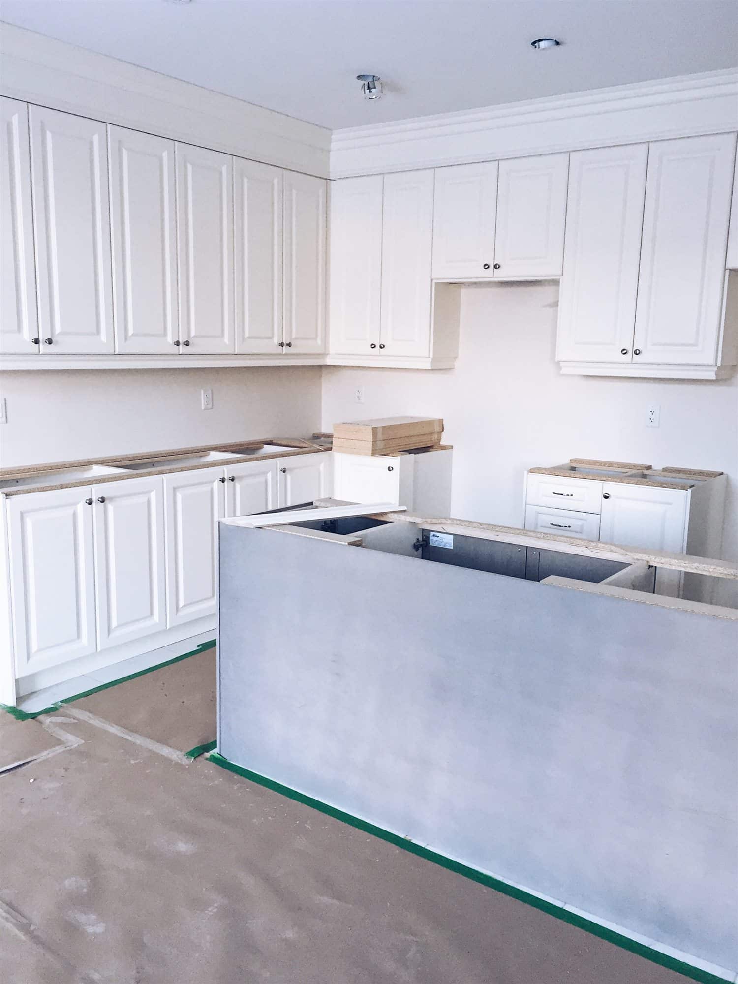 A kitchen with white painted cabinet doors and a fitted worktop