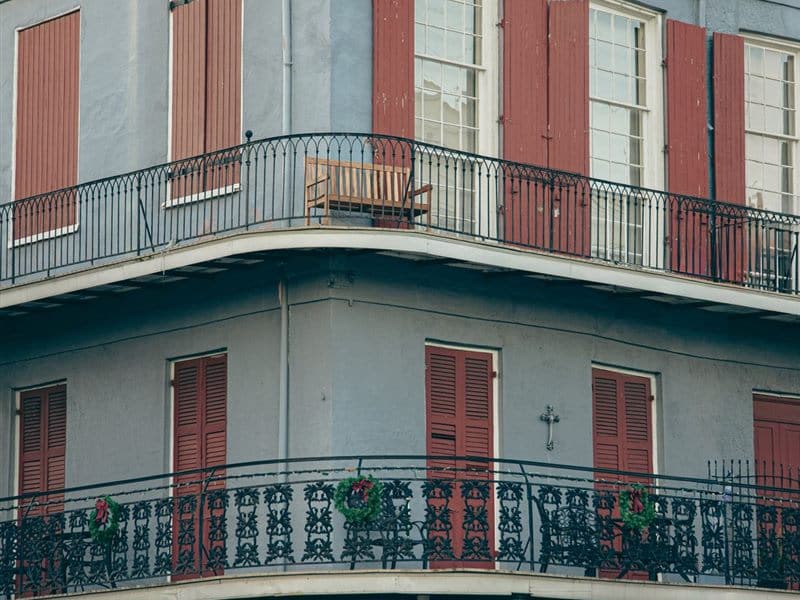 A French Quarter facade with painted shutters and an iron balcony