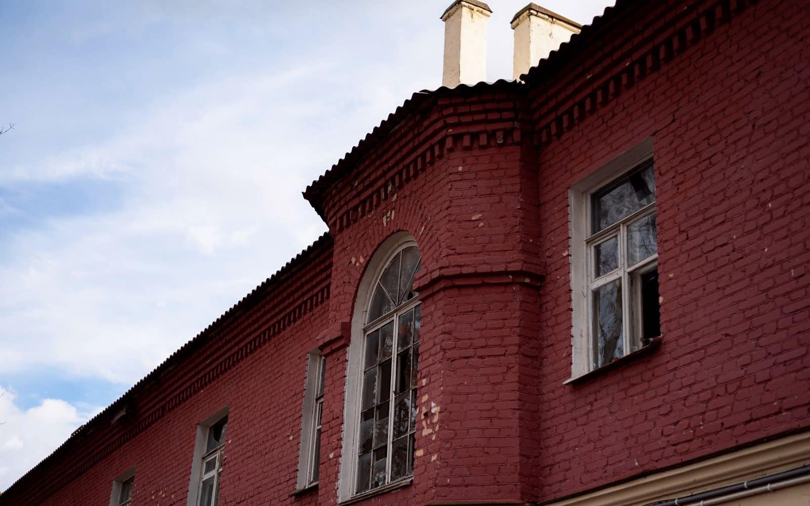 A brick and stucco exterior part way through painting